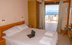 a bedroom with a bed with a laptop on it at Dionysos Apartments in Apraos