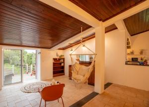 un salon avec un hamac suspendu au plafond dans l'établissement Casa Capelas, à São Vicente Ferreira 29 autres photos