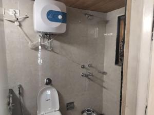 a bathroom with a toilet with a camera on the wall at Explore bharat in Kedārnāth