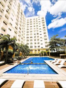 a swimming pool in front of a large building at Holland Park in Biñan