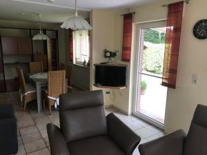 a living room with a couch and a television and a table at Kleymann RE26 in Sögel