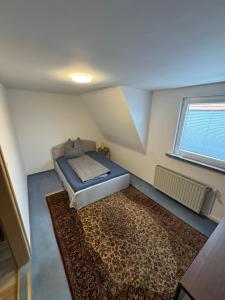 Un dormitorio pequeño con una cama y una alfombra. en Ferienhaus WorkersParadise, en Elxleben