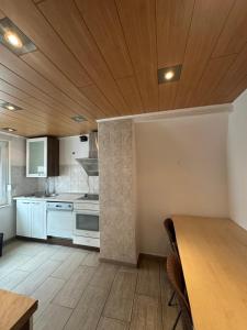 a kitchen with white appliances and a wooden ceiling at Shakina Residences near Frankfurt Airport in Rüsselsheim