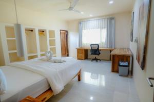 una camera da letto con un letto, una scrivania e una sedia di Central house with 2 large bedrooms a Kuta Lombok