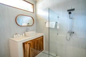 un bagno con lavandino e doccia con specchio di Central house with 2 large bedrooms a Kuta Lombok Altre 11 foto