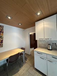 a kitchen with white cabinets and a wooden table at Shakina Residences near Frankfurt Airport in Rüsselsheim +29 photos
