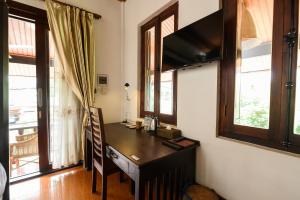 a room with a desk in a room with windows at Treasure Heritage Hotel in Luang Prabang