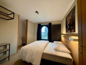 Un dormitorio con una cama grande con ventana. en Le Manoir, en Nassogne 52 fotos más