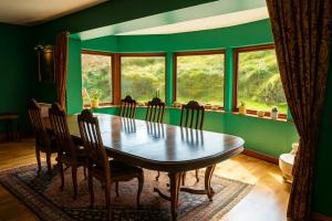a dining room with a table and chairs and windows at Ocean View Lodge in Kilchiaran