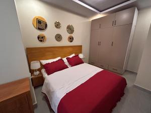 1 dormitorio con 1 cama y armarios de color rojo y blanco en The Rooftop Oasis Rebero - Kigali, en Kigali