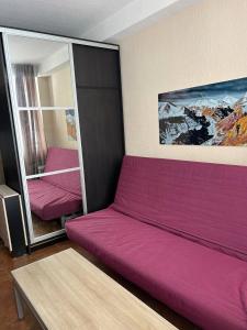 a purple couch in a room with a bed at 2-room Apartment NFT Gudauri Penta 404 in Gudauri