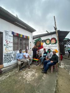 a group of people sitting in front of a building at Isabella Hostel in Shillong