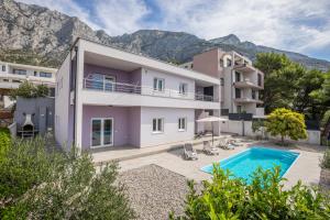 une villa avec une piscine et des montagnes en arrière-plan dans l'établissement VILLA VIS MARIS, à Makarska