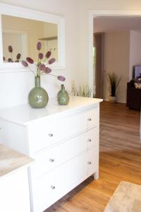 a white dresser with a vase with flowers on it at Knipper RE24 in Sögel