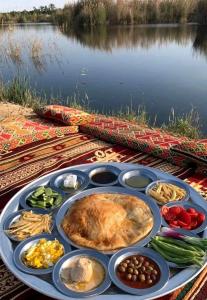 a tray of food on a table next to a body of water at Luna Nile in Aswan