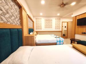 a hotel room with two beds and a table at Hotel Aishwarya Residency in Nerul +25 photos