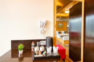 a hotel room with a desk and a bed at Rockland Cottage Manali - Centrally Heated & Air Cooled Premium Rooms in Manāli