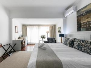 a bedroom with a large bed and a desk at Emmarentia Guest House in Johannesburg +50 photos