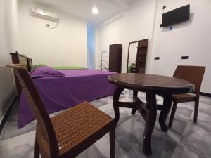 a room with a table and chairs and a bed at Onera Hotel & restaurant in Mahiyangana