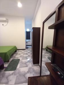 a room with a green bed and a mirror at Onera Hotel & restaurant in Mahiyangana +10 photos
