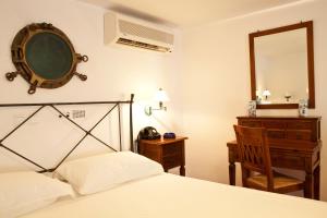 プラティスヤロス・シフノスにあるAlexandros Hotelのベッドルーム1室(ベッド1台、鏡、椅子付)