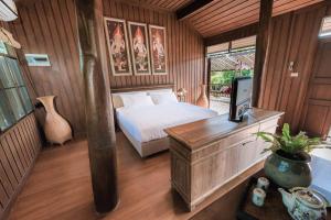 a bedroom with a bed and a desk with a television at Cyngam Retreat- A private pool villa with service in Ban Pa Sao +62 photos