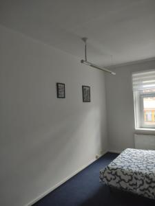 ein weißes Zimmer mit einem Bett und einem Fenster in der Unterkunft Zizkov Stay - Close to Center in Prag