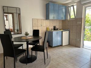 une cuisine avec une table et des chaises dans une pièce dans l'établissement Apartments Suzana, à Herceg-Novi 14 autres photos