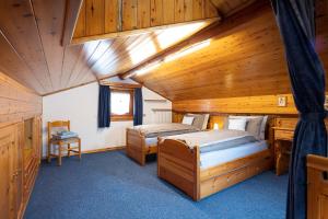 a bedroom with two beds in a wooden house at Chalet Edera Myholidaylivigno in Livigno