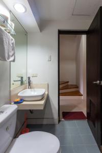 a bathroom with a white sink and a toilet at California Home at Marcon Suites in Baguio