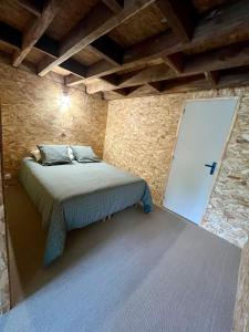 CommerにあるGîte du Moulinの石の壁の中にベッドが置かれた寝室