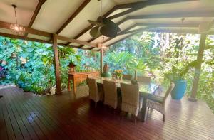 a porch with a table and chairs and plants at Karinya in Clifton Beach
