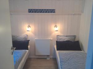 HestoftにあるSkipper-Lodge Westのベッド2台 壁に照明が付く部屋