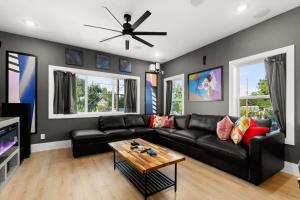 a living room with a black couch and a table at City Views Rooftop Karaoke, Pool, Hot Tub, Games in San Antonio
