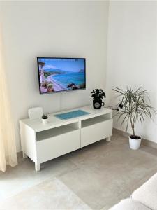 a white living room with a tv on a wall at Appartamento a Pula in Pula