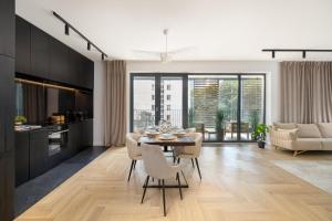 a kitchen and dining room with a table and chairs at Luxurious Apartment with a Terrace and Garage - Grzybowska in Warsaw