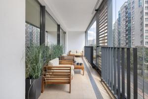 a balcony with chairs and tables and windows at Luxurious Apartment with a Terrace and Garage - Grzybowska in Warsaw