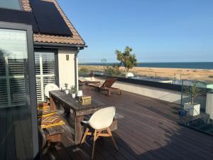 a deck with chairs and a table and the beach at Stunning Beach House Indoor Pool in Portsmouth
