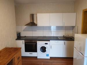 a kitchen with white cabinets and a washing machine at Siedlungsstr 19 Bruchsal Ap 40 in Bruchsal
