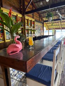 a long table in a restaurant with a pink flamingo on it at On the Rocks in Koh Rong Sanloem +31 photos