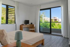 a bedroom with a bed and a large window at Serenity in La Gaulette