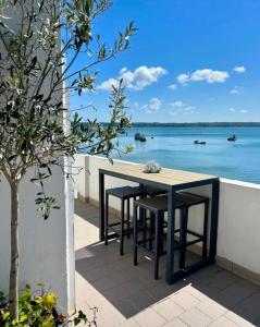 a table and chairs on a balcony with a view of the water at BB les pieds dans L'eau CARANTEC in Carantec