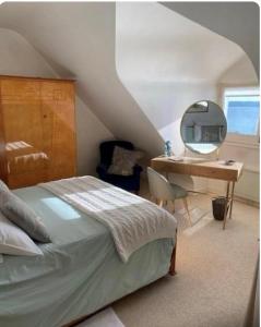 a bedroom with a bed and a desk with a mirror at BB les pieds dans L'eau CARANTEC in Carantec