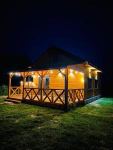 eine große Holzhütte mit Nachtlicht in der Unterkunft Domek z jacuzzi i kominkiem - cisza, natura, relaks 
