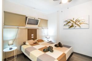 サン・バルトロメにあるBeautiful Apartment 1115 Centralのベッドが2つと壁にテレビがある寝室 +19枚の写真