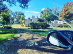 a side view mirror of a car driving down a road at Amanzi Lodge in Greytown