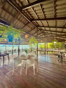 a dining area with a table and chairs and the ocean at On the Rocks in Koh Rong Sanloem