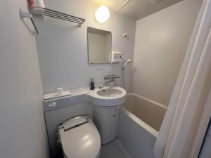 a bathroom with a toilet and a sink and a mirror at DOMO Hotel 大津 in Ozu +47 photos
