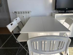 a white table and a chair and a television at Il terrazzino sul Golfo in Recco