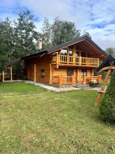 a log cabin with a large yard in front of it at Pensiunea Plaiul Bucovinei in Şarul Dornei +15 photos